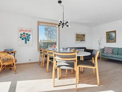 a dining room and living room with a table and chairs at Holiday Home Alvira - 8km to the fjord by Interhome in Fjerritslev