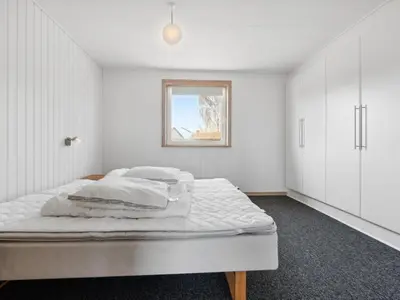 a bedroom with a bed with white walls and a window at Holiday Home Alvira - 8km to the fjord by Interhome in Fjerritslev