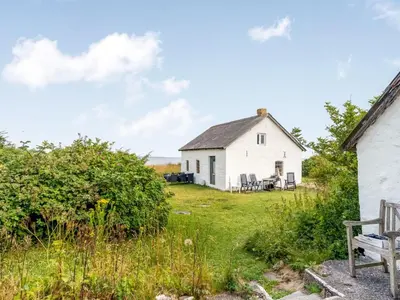a white house with a bench in front of it at Holiday Home Agrippa - 30m to the fjord by Interhome in Løgstør