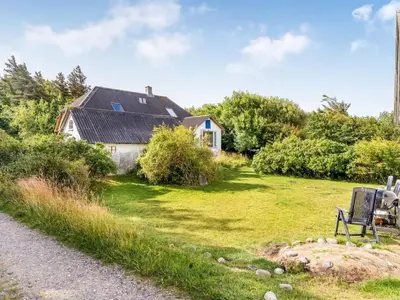 a bench sitting in the grass in front of a house at Holiday Home Agrippa - 30m to the fjord by Interhome in Løgstør