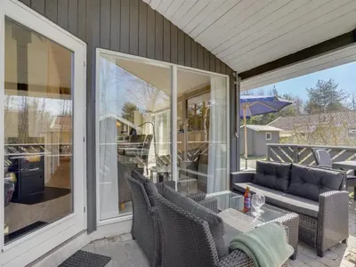 a screened in porch with chairs and a table at Holiday Home Sighbiorn - 950m from the sea by Interhome in Fjerritslev