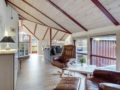a living room with leather chairs and a table at Holiday Home Thurir - 4km from the sea by Interhome in Fjerritslev