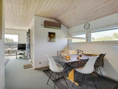 a kitchen and dining room with a table and chairs at Holiday Home Ordan - 800m from the sea by Interhome in Fjerritslev