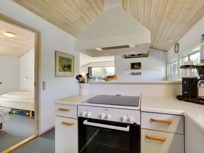 a kitchen with a stove top oven in a room at Holiday Home Ordan - 800m from the sea by Interhome in Fjerritslev