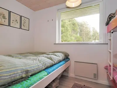 a small bedroom with a bed and a window at Holiday Home Oberon - 3km from the sea by Interhome in Fjerritslev