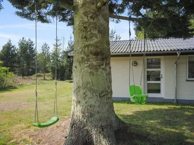 a tree with two swings in front of a house at Holiday Home Oberon - 3km from the sea by Interhome in Fjerritslev
