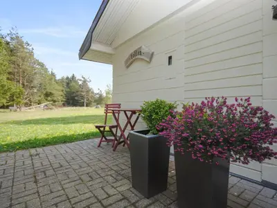 a patio with a picnic table and some flowers at Holiday Home Oberon - 3km from the sea by Interhome in Fjerritslev