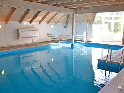 a large pool with blue water in a building at Holiday Home Roulf - 1-1km from the sea by Interhome in Fjerritslev