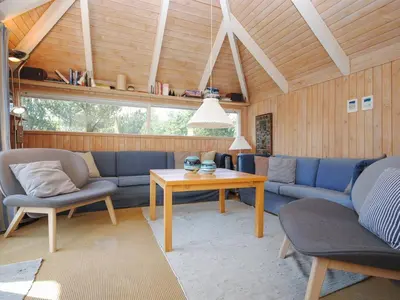 a living room with a blue couch and a table at Holiday Home Roulf - 1-1km from the sea by Interhome in Fjerritslev