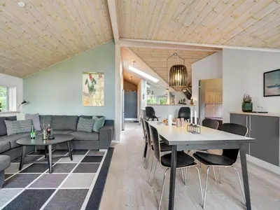 a living room with a couch and a table and chairs at Holiday Home Grimi - 4km from the sea by Interhome in Fjerritslev