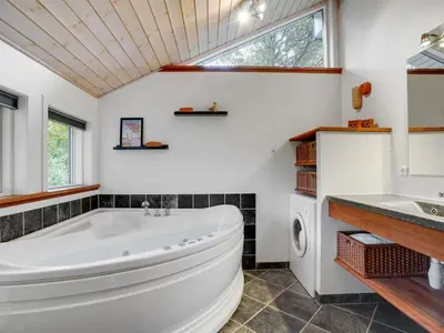 a bathroom with a large tub and a sink at Holiday Home Grimi - 4km from the sea by Interhome in Fjerritslev