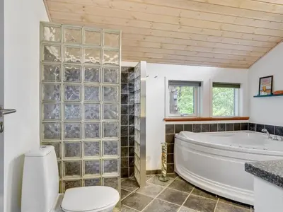a bathroom with a tub and a toilet at Holiday Home Grimi - 4km from the sea by Interhome in Fjerritslev
