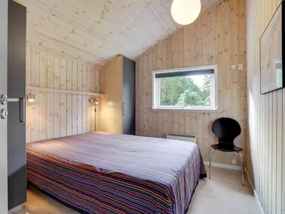 a bedroom with a large bed and a window at Holiday Home Grimi - 4km from the sea by Interhome in Fjerritslev
