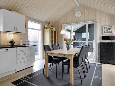 a kitchen and dining room with a wooden table and chairs at Holiday Home Henriete - 3-5km from the sea by Interhome in Fjerritslev