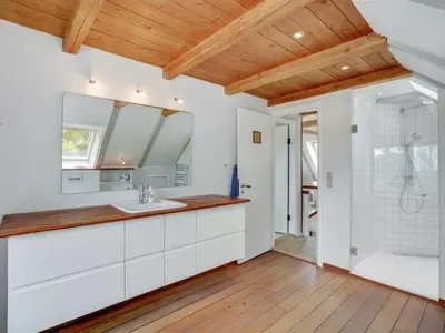 a bathroom with white cabinets and a shower and a sink at Holiday Home Nella - 1-2km from the sea by Interhome in Fjerritslev