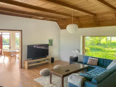 a living room with a blue couch and a tv at Holiday Home Nella - 1-2km from the sea by Interhome in Fjerritslev