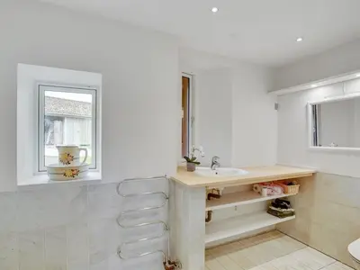 a white bathroom with a sink and a window at Holiday Home Nella - 1-2km from the sea by Interhome in Fjerritslev