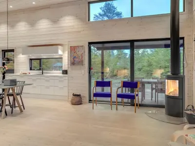 a living room with blue chairs and a stove at Holiday Home Gunnor - 1-3km from the sea by Interhome in Fjerritslev