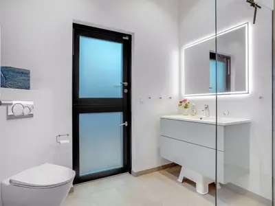 a bathroom with a toilet and a sink and a mirror at Holiday Home Gunnor - 1-3km from the sea by Interhome in Fjerritslev