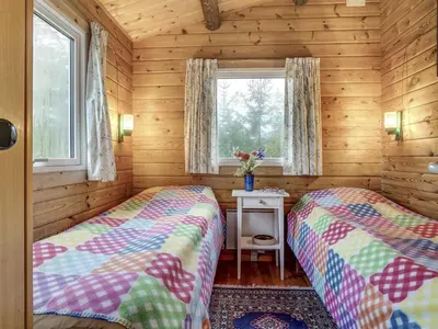 two beds in a log cabin bedroom with a window at Holiday Home Artur - 1-5km from the sea by Interhome in Fjerritslev