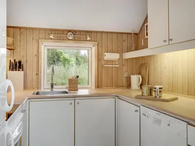 a kitchen with white cabinets and a window at Holiday Home Gunnie - 1-1km from the sea by Interhome in Fjerritslev