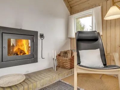 a living room with a chair and a fireplace at Holiday Home Gunnie - 1-1km from the sea by Interhome in Fjerritslev