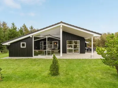 a black house with a white roof at Holiday Home Frida - 700m from the sea by Interhome in Fjerritslev