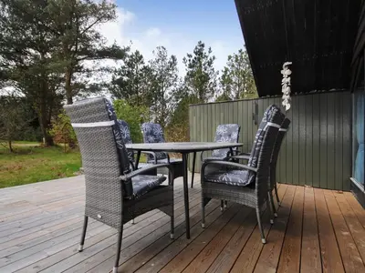 a patio table and chairs on a deck at Holiday Home Deni - 4km from the sea by Interhome in Fjerritslev