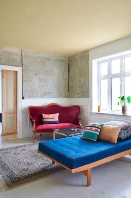 a living room with a bed and a red couch at 18b Ferielejlighed in Harboør