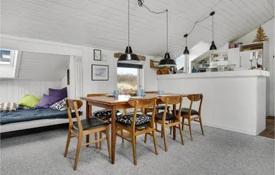 a dining room with a table and chairs and a bed at Amazing Home In Thisted With Sauna in Torsted