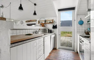 a kitchen with white cabinets and a large window at Amazing Home In Thisted With Sauna in Torsted
