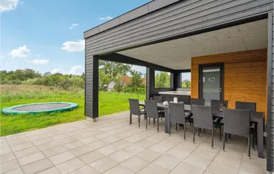 a patio with a table and chairs and a pool at Awesome Home In Løgstrup With Kitchen in Løgstrup