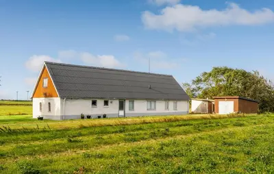 a white barn with a black roof in a field at 2 Bedroom Nice Home In Bedsted Thy in Bedsted Thy