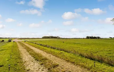 a field of green grass with a dirt road at 2 Bedroom Nice Home In Bedsted Thy in Bedsted Thy