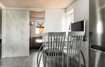a kitchen with a table with chairs and a refrigerator at 2 Bedroom Nice Home In Bedsted Thy in Bedsted Thy
