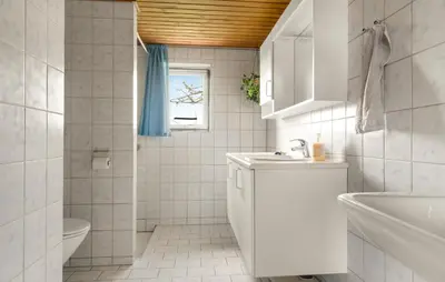 a bathroom with a sink and a toilet and a window at 2 Bedroom Nice Home In Bedsted Thy in Bedsted Thy