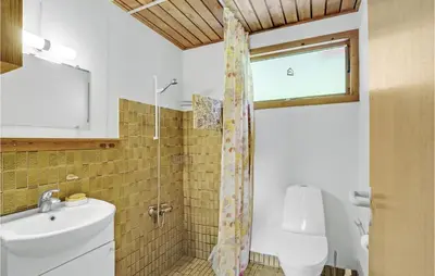 a bathroom with a sink and a toilet and a window at Amazing Home In Nykøbing M in Hesselbjerg