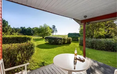 a table on a deck with a view of a yard at Amazing Home In Nykøbing M in Hesselbjerg