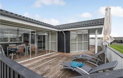 a deck with chairs and a table with a dining room at Beautiful Home In Vinderup With Sauna in Vinderup