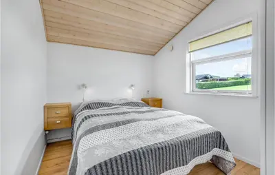 a white bedroom with a bed and a window at Beautiful Home In Vinderup With Sauna in Vinderup