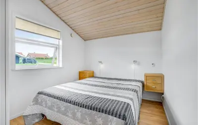 a bedroom with a bed and a window at Beautiful Home In Vinderup With Sauna in Vinderup