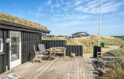 a patio with a table and chairs on a wooden deck at Beautiful Home In Pandrup With Wifi in Pandrup