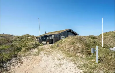 a building on top of a hill with a dirt road at Beautiful Home In Pandrup With Wifi in Pandrup
