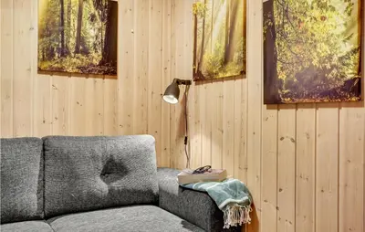a living room with a couch and paintings on the wall at Amazing Home In Thyholm With Wifi in Thyholm