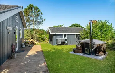 a backyard with a grill and a house at Cozy Home In Hurup Thy With Sauna in Sønder Ydby