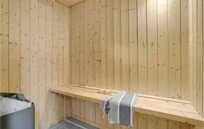 a wooden sauna with a towel on a bench at Cozy Home In Hurup Thy With Sauna in Sønder Ydby