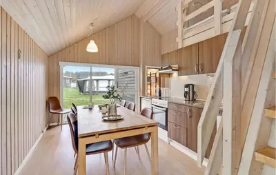 a kitchen and dining room with a table and chairs at Nice Home In Hanstholm With Kitchen in Hanstholm