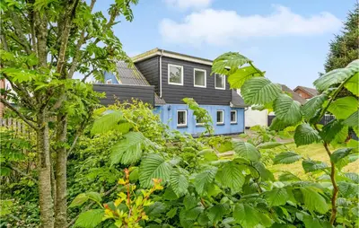 a blue house with green trees in front of it at Gorgeous Home In Nykøbing M With Wifi in Tødsø