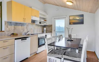 a kitchen with a table and a dining room at 2 Bedroom Amazing Home In Hanstholm in Hanstholm