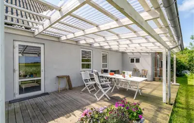 a pergola on a deck with a table and chairs at Gorgeous Home In Vestervig With Wifi in Vestervig